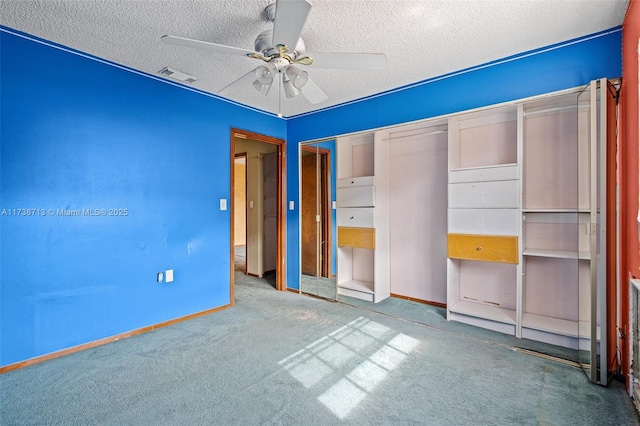 unfurnished bedroom with ceiling fan, a closet, carpet, and a textured ceiling