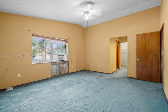 spare room featuring cooling unit, vaulted ceiling, light colored carpet, and a textured ceiling