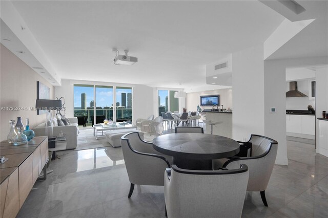 dining space featuring marble finish floor, visible vents, and a city view