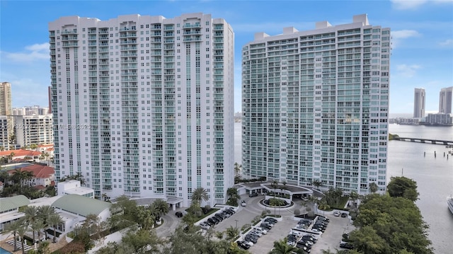 view of building exterior featuring a city view and a water view