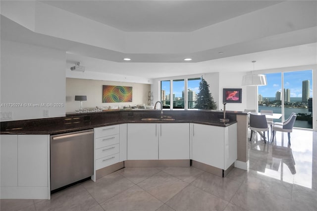 kitchen with sink, decorative light fixtures, dishwasher, dark stone counters, and white cabinets