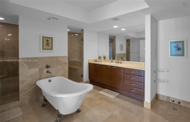 bathroom featuring vanity, separate shower and tub, tile patterned flooring, and tile walls