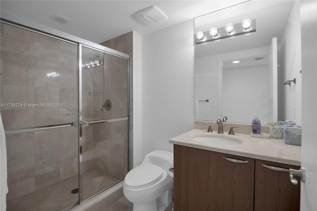 bathroom featuring vanity, a shower with door, and toilet