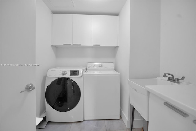 clothes washing area with cabinets, light tile patterned flooring, washer and dryer, and sink