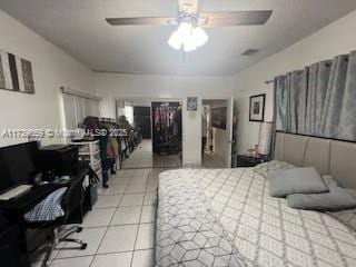 tiled bedroom featuring ceiling fan