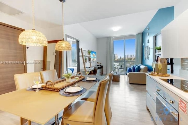 dining space with expansive windows and light hardwood / wood-style floors