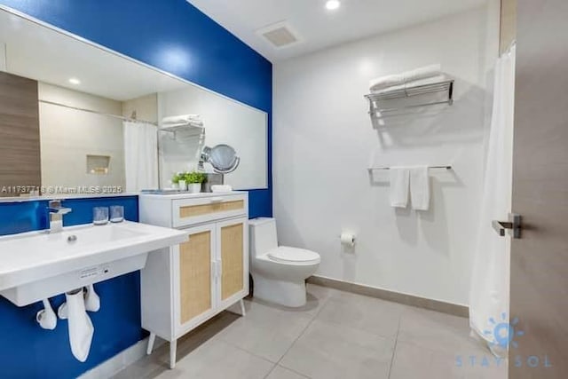 bathroom with toilet and tile patterned flooring