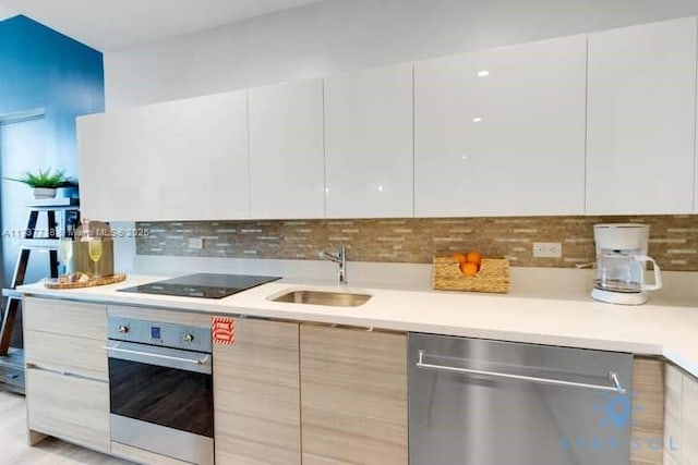 kitchen featuring sink, white cabinetry, stainless steel appliances, decorative backsplash, and light brown cabinets