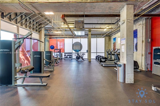 exercise room featuring a towering ceiling