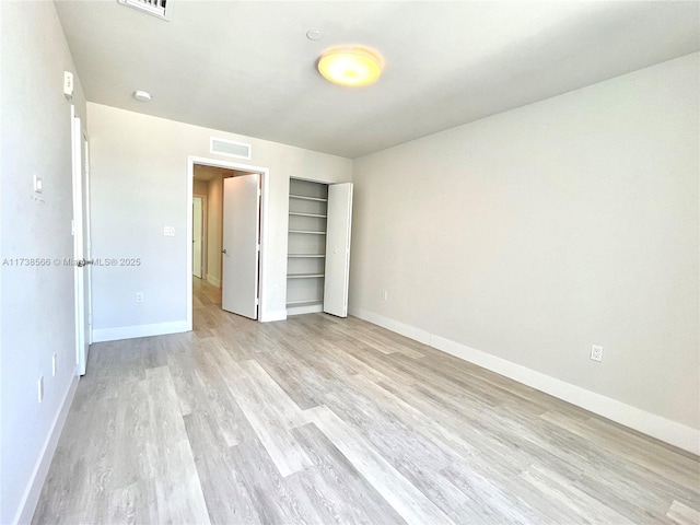 unfurnished bedroom with light hardwood / wood-style floors and a closet