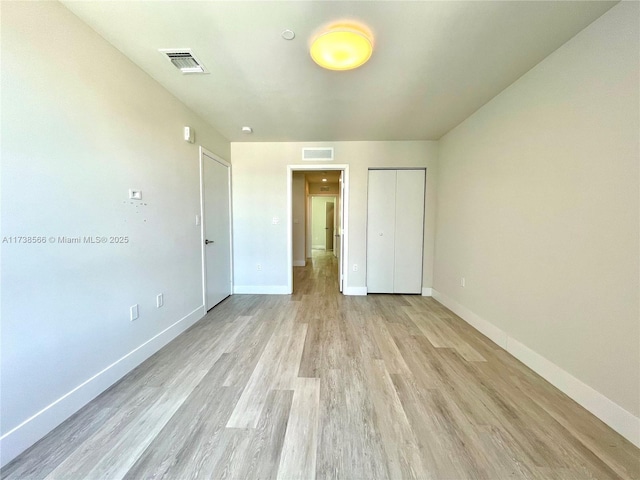 unfurnished bedroom with a closet and light wood-type flooring