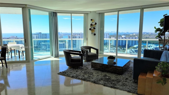 living room featuring tile patterned flooring and a wall of windows