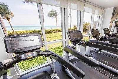 exercise room with a healthy amount of sunlight and a water view