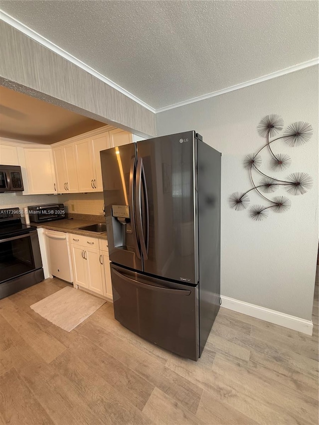 kitchen with white cabinets, light hardwood / wood-style floors, black appliances, crown molding, and a textured ceiling