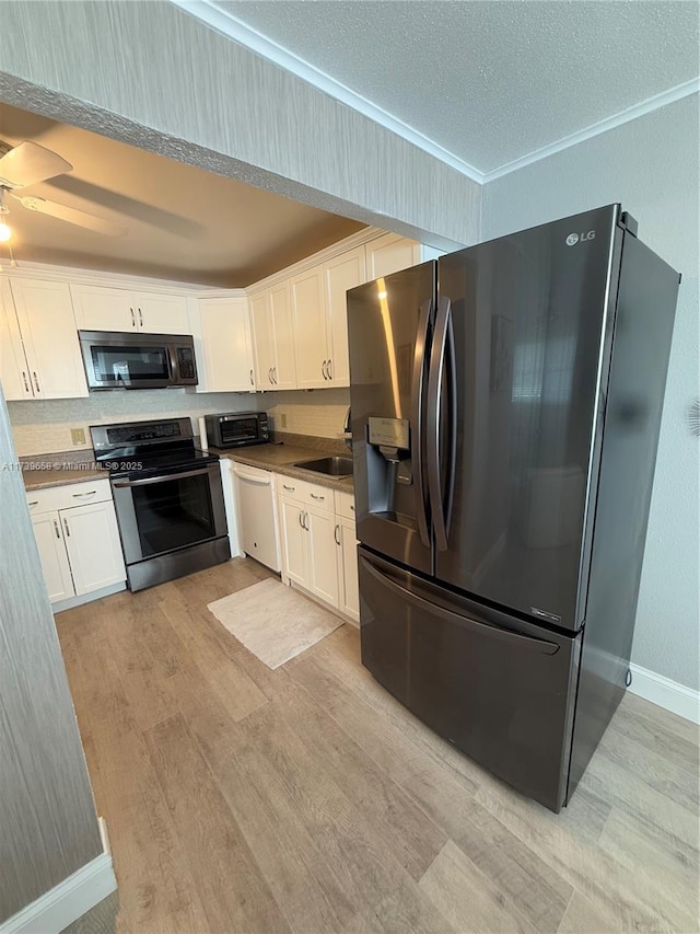 kitchen with white cabinets, sink, fridge with ice dispenser, and stainless steel range with electric stovetop