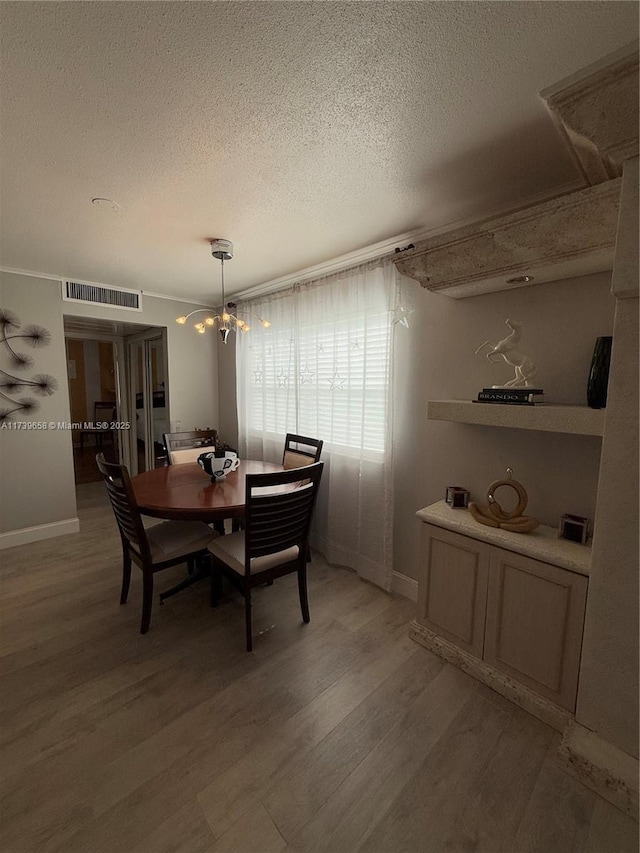 dining room featuring a chandelier, hardwood / wood-style floors, and a textured ceiling