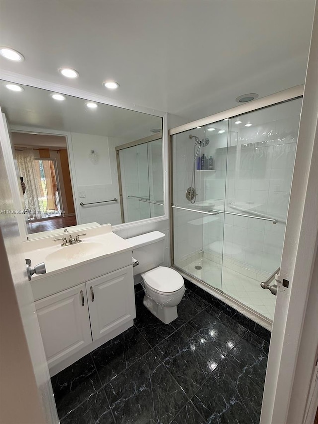 bathroom with vanity, toilet, and an enclosed shower