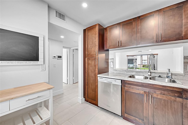 kitchen with stainless steel dishwasher, sink, and light tile patterned floors