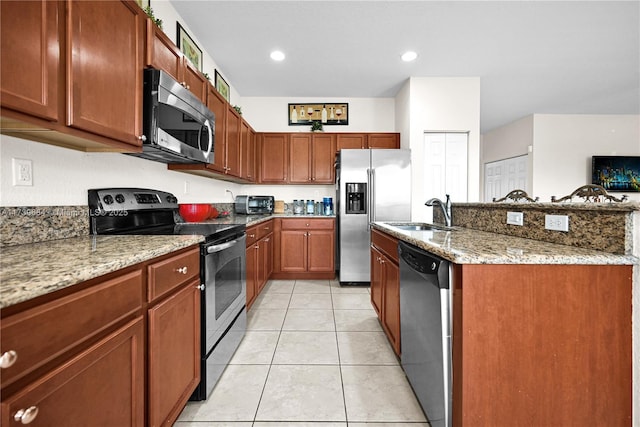 kitchen featuring stainless steel appliances, light stone countertops, sink, and light tile patterned floors