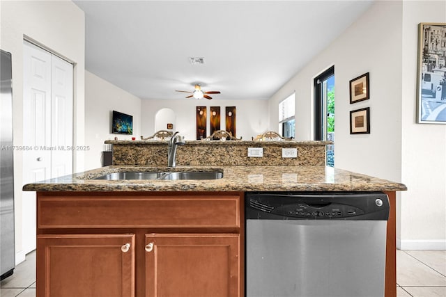 kitchen with dishwasher, sink, light tile patterned floors, and light stone counters