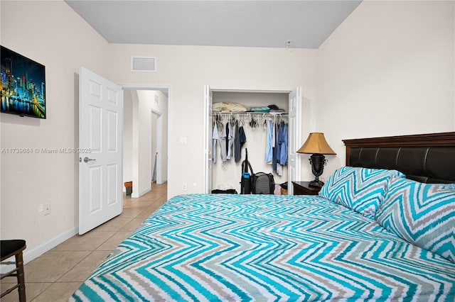 bedroom with tile patterned flooring and a closet