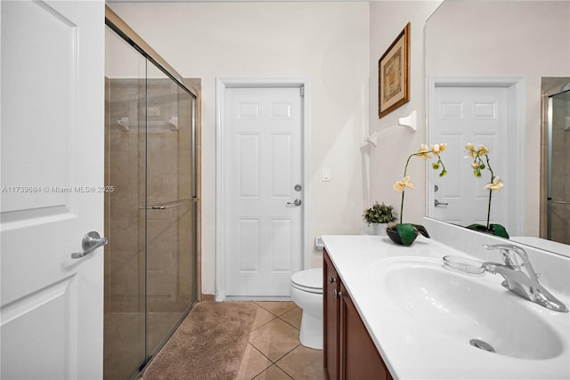 bathroom with tile patterned floors, toilet, an enclosed shower, and vanity