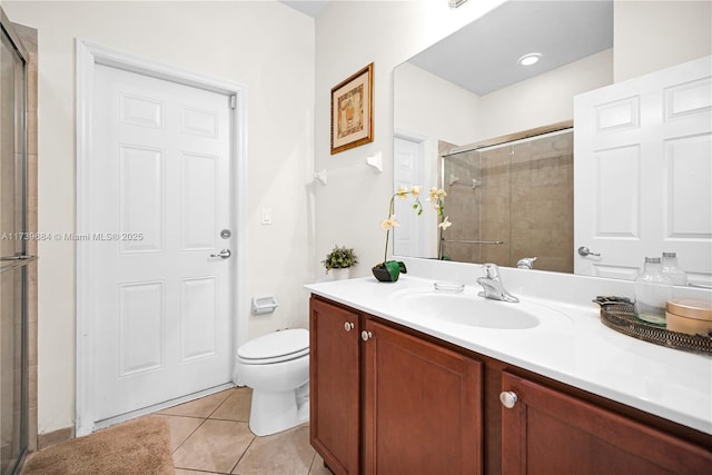 bathroom featuring tile patterned flooring, vanity, a shower with shower door, and toilet