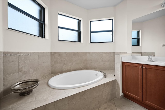 bathroom featuring vanity, a relaxing tiled tub, and tile patterned floors