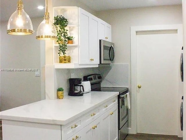 kitchen featuring white cabinetry, hanging light fixtures, backsplash, and appliances with stainless steel finishes