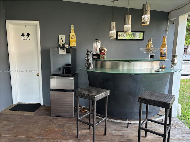 bar featuring pendant lighting and hardwood / wood-style flooring