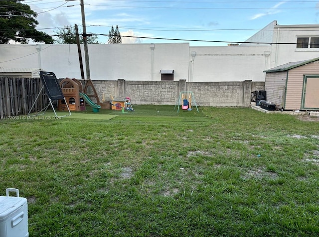 view of yard featuring a playground and a storage unit