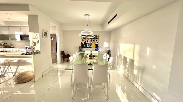 dining room with light tile patterned floors and baseboards