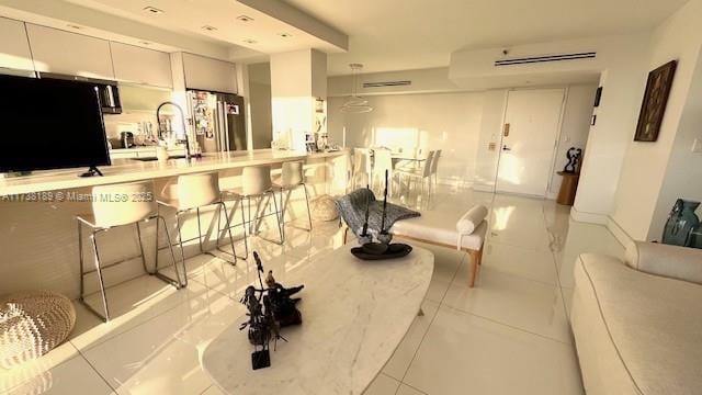 living area featuring tile patterned floors and a wall unit AC