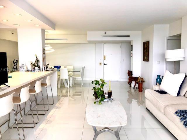 living room with light tile patterned floors and a wall unit AC