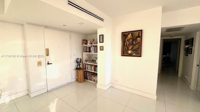 hallway with light tile patterned floors and baseboards