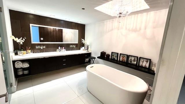 full bath with a freestanding bath, double vanity, and tile patterned floors