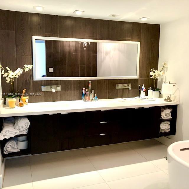 bathroom featuring vanity, tile patterned floors, and tasteful backsplash