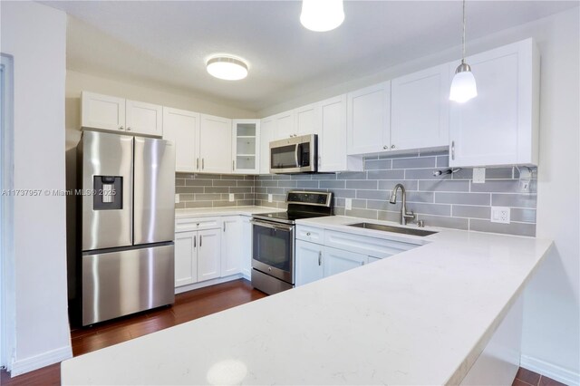 kitchen featuring white cabinetry, appliances with stainless steel finishes, sink, and pendant lighting