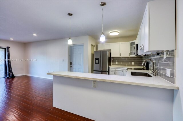 kitchen featuring white cabinetry, stainless steel appliances, kitchen peninsula, and sink