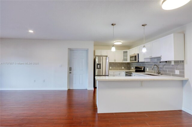 kitchen with decorative light fixtures, white cabinetry, sink, decorative backsplash, and stainless steel appliances