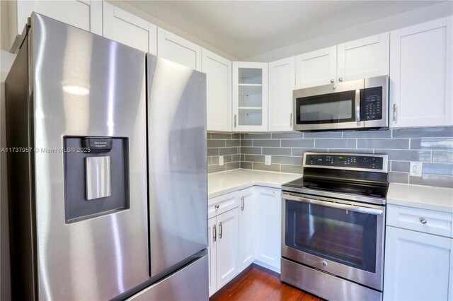 kitchen with white cabinetry, decorative backsplash, stainless steel appliances, and dark hardwood / wood-style floors