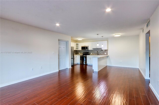 unfurnished living room with dark hardwood / wood-style floors and sink