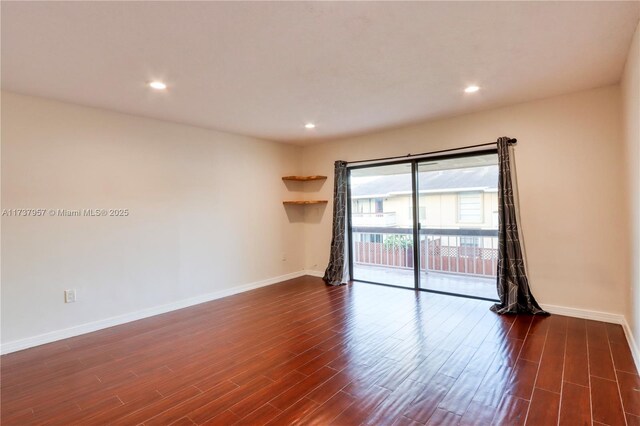 spare room with dark hardwood / wood-style flooring