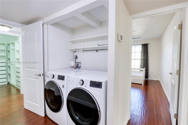 clothes washing area featuring dark wood-type flooring, washer and dryer, and a textured ceiling