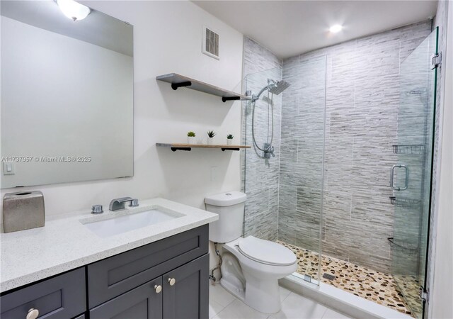 bathroom with vanity, an enclosed shower, tile patterned flooring, and toilet