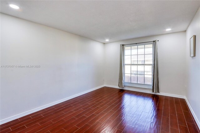 unfurnished room with dark hardwood / wood-style flooring