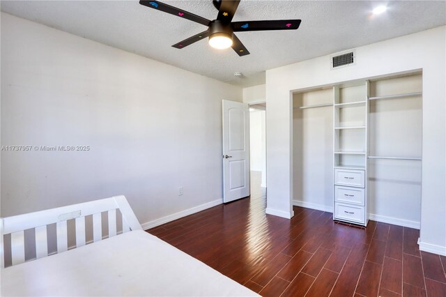 unfurnished bedroom featuring dark wood-type flooring, a closet, and a textured ceiling