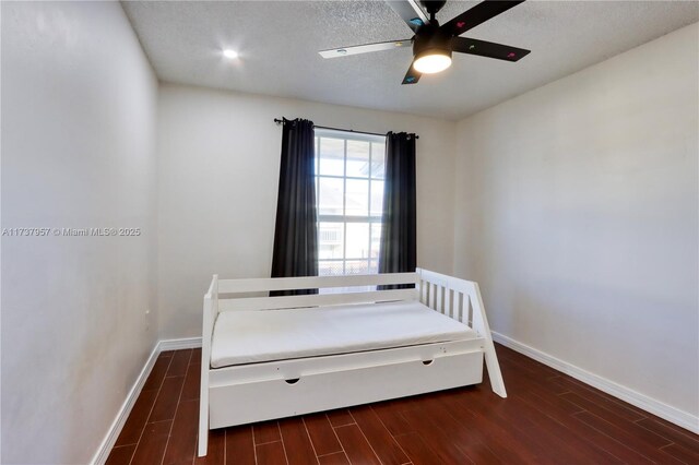 unfurnished bedroom featuring dark hardwood / wood-style floors, a textured ceiling, and ceiling fan