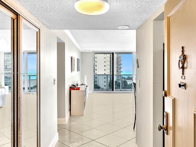 hallway with light tile patterned floors and a textured ceiling