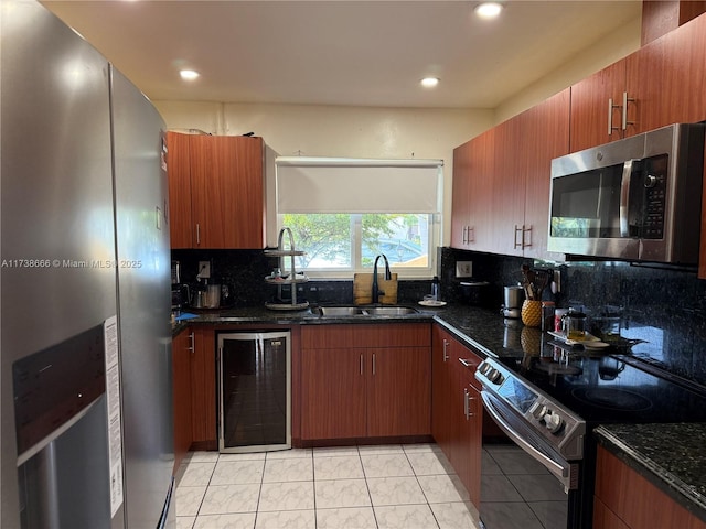 kitchen with dark stone countertops, sink, stainless steel appliances, and beverage cooler